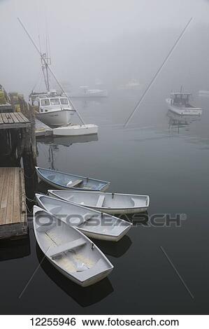 Stock Photograph - Lobster boats, dinghys in fog; New Harbor, Maine, United States of America. Fotosearch