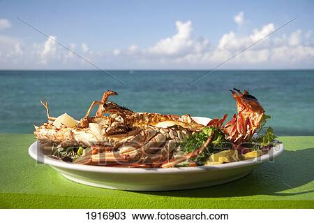 Stock Image - Lobster Dish At Compass Point Resort Hotel Restaurant, Sea In The Background. Fotosearch