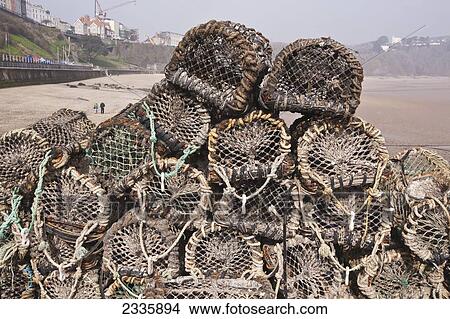 Picture - Lobster Pots At Harbor With North Beach In Background; Tenby, Pembrokeshire Coast Path, Wales, United Kingdom. Fotosearch