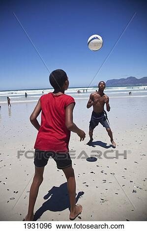 Stock Photograph - Local Boys Playing Football On The Beach, Muizenberg; Local Boys Playing Football On Beach, Muizenberg, Cape Town, South Africa&#13; &#10. Fotosearch