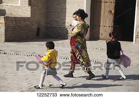 Stock Image - Local family, Cheshma Ayub (Spring of Job), Old Town; Bukhara, Uzbekistan. Fotosearch