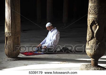 Stock Photo - Local man praying inside Jummi mosque, inside Ichan Kala Old City; Khiva, Khwarezm, Uzbekistan. Fotosearch