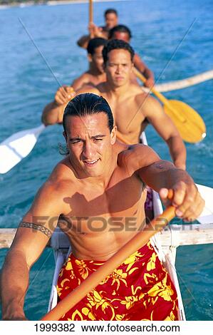 Stock Image - Local Men In Outrigger Canoe Close-Up Paddling, Hawaiian Print Wrap. Fotosearch