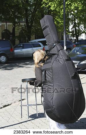 Local musician carrying a large musical instrument to her next performance within the Old Town; Tallinn, Estonia View Large Photo Image Picture - Local musician carrying a large musical instrument to her next performance within the Old Town; Tallinn, Estonia. Fotosearch