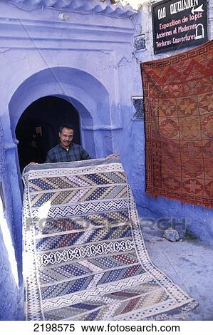 Stock Photography - Local Selling Carpet In Market, Streets Of Chaouen (Chefchaouen Or Xaouen), Morocco.. Fotosearch