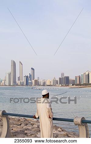 Local UAE man looking at Abu Dhabi cityscape; Abu Dhabi, United Arab Emirates View Large Photo Image Stock Image - Local UAE man looking at Abu Dhabi cityscape; Abu Dhabi, United Arab Emirates. Fotosearch