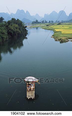 Stock Image - Locals On Raft On Ya Long River, Guangxi, China. Fotosearch