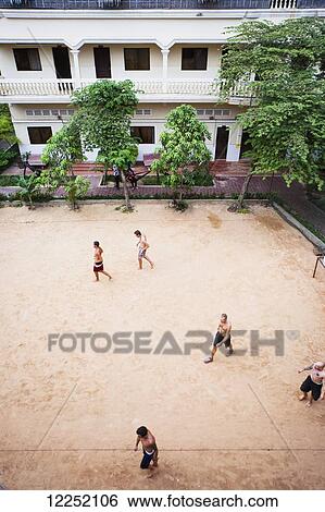 Stock Photograph - Locals play soccer on outdoor pitch; Siem Reap, Cambodia. Fotosearch