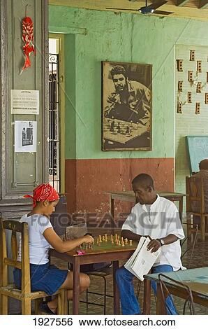 Stock Photograph - Locals Playing Chess At A Chess Club, With A Poster Of Che Guevara In The Background, Santiago De Cuba, Cuba. Fotosearch
