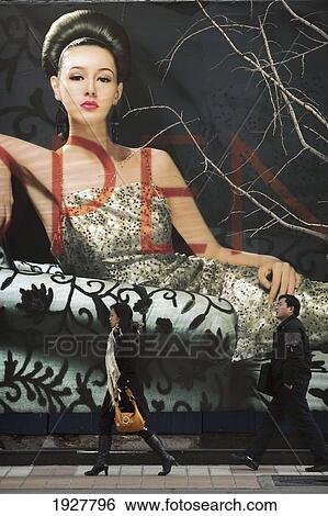 Stock Photograph - Locals Walk Past A Large Advertisement On Wangfujing Street, One Of The Beijing's Most Famous Shopping Streets, Beijing, China. Fotosearch
