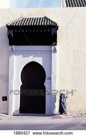 Stock Photo - Locals Walking By Wall Of Boujeloud Mosque. Fotosearch
