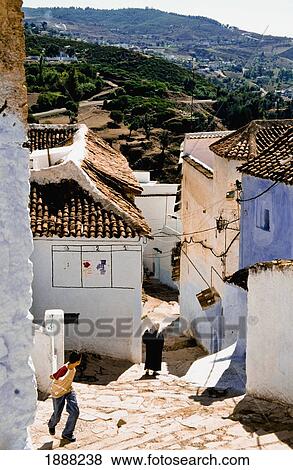 Locals Walking Through Streets Of Chaouen View Large Photo Image Stock Photo - Locals Walking Through Streets Of Chaouen. Fotosearch