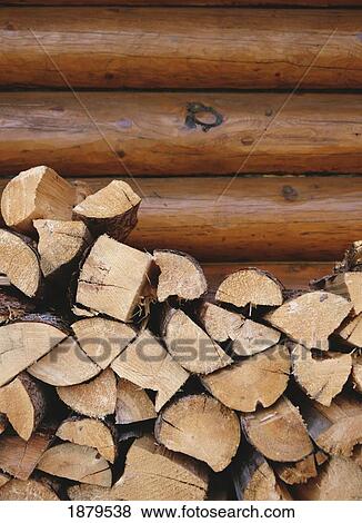 Stock Photo - Logs Stacked Up In Front Of A Log Cabin, Canada. Fotosearch