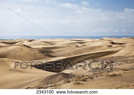 Stock Image - Lone Walker On The Sand Dunes; Maspalona, Gran Canaria, Spain. Fotosearch