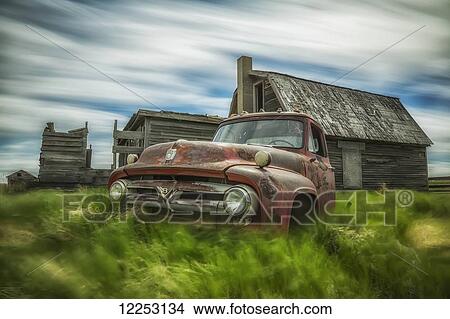 Long exposure of clouds drifting by over an abandoned truck and house in a rural area; Saskatchewan, Canada View Large Photo Image Picture - Long exposure of clouds drifting by over an abandoned truck and house in a rural area; Saskatchewan, Canada. Fotosearch