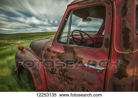 Stock Photography - Long exposure of clouds drifting by over an abandoned truck in a rural area; Saskatchewan, Canada. Fotosearch