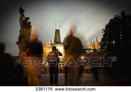 Stock Photography - Long exposure of people standing on Charles Bridge at dusk; Prague, Czech Republic. Fotosearch