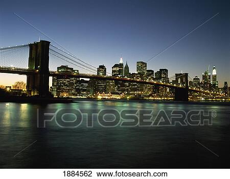 Stock Image - Looking Across The East River And The Brooklyn Bridge To The Financial District At Dusk. Fotosearch