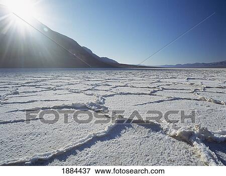 Stock Photo - Looking Across The Saltpans Early In The Morning With Sun Shining Over Mountain. Fotosearch