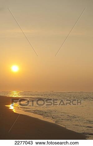 Stock Image - Looking along beach to rising sun, near Unawatuna; Thalpe, Sri Lanka. Fotosearch