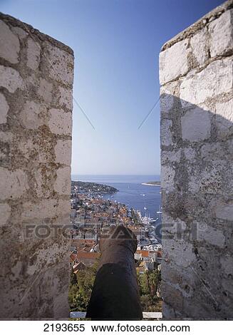 Looking Along Old Cannon In The Citadel To The Harbourfront And Town Of Hvar, Hvar, Croatia. View Large Photo Image Stock Photography - Looking Along Old Cannon In The Citadel To The Harbourfront And Town Of Hvar, Hvar, Croatia.. Fotosearch