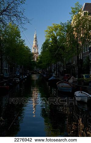 Looking along small canal with the spire of the Zuiderkerk church at the end at dusk; Amsterdam, Holland View Large Photo Image Stock Image - Looking along small canal with the spire of the Zuiderkerk church at the end at dusk; Amsterdam, Holland. Fotosearch