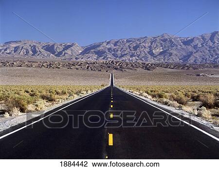 Stock Image - Looking Down Long Straight Road Towards Mountains. Fotosearch