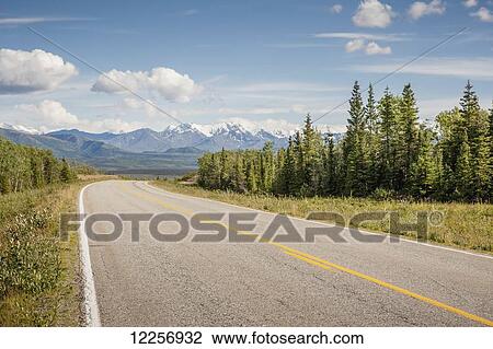 Stock Image - Looking down the Richardson Highway at a distant mountain range, Alaska, Summer. Fotosearch