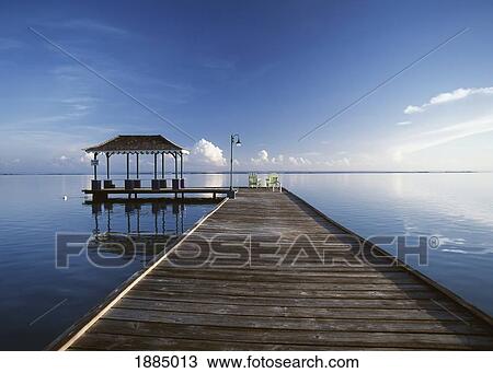Stock Image - Looking Down Wooden Pier At Dawn. Fotosearch