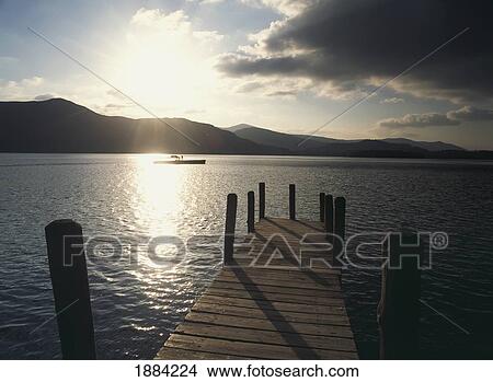 Looking Down Wooden Pier Towards Boat At Dusk On Derwent Water View Large Photo Image Picture - Looking Down Wooden Pier Towards Boat At Dusk On Derwent Water. Fotosearch