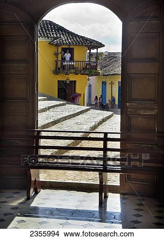 Picture - Looking Out Arched Side Door Of Church To Colonial Building As Man Stands On Balcony; Trinidad, Sancti Spiritus, Cuba. Fotosearch
