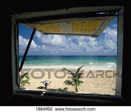 Stock Image - Looking Out Of Window Onto White Sand Long Bay Beach. Fotosearch