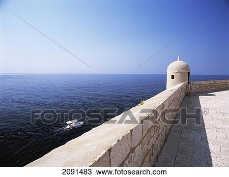 Stock Image - Looking Out To Sea And To Small Boat Beneath The City Walls Of Dubrovnik, Croatia.. Fotosearch