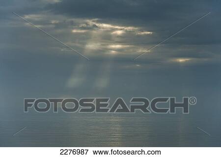 Looking out to sea from Camber Sands on cloudy day with rays of sunshine; East Sussex, England View Large Photo Image Stock Photo - Looking out to sea from Camber Sands on cloudy day with rays of sunshine; East Sussex, England. Fotosearch
