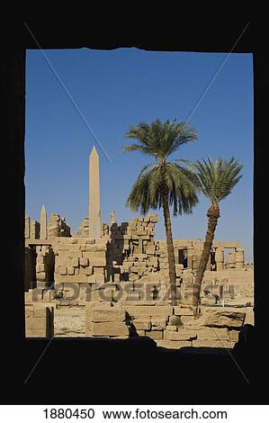 Stock Image - Looking Through Columns To Hatshepsut's Obelisk And Date Palms. Fotosearch