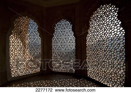 Stock Image - Looking through stone lattice window to the walls of Amber Fort; Amer, Jaipur, India. Fotosearch