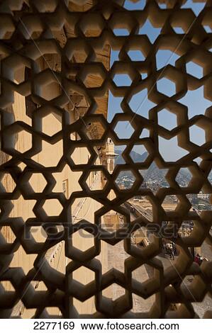 Stock Photo - Looking through stone lattice window to the walls of Amber Fort; Amer, Jaipur, India. Fotosearch