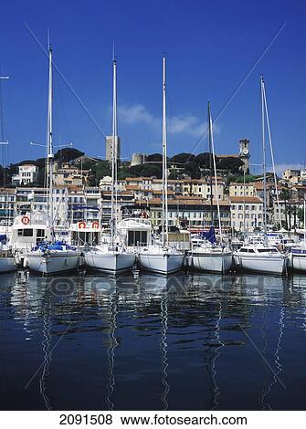 Looking Through Yachts In The Harbour To The Old Quarter Of Cannes, France. View Large Photo Image Stock Photo - Looking Through Yachts In The Harbour To The Old Quarter Of Cannes, France.. Fotosearch