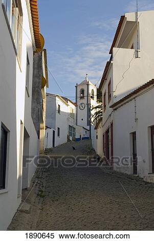 Stock Photography - Looking Up Village Street Towards Church. Fotosearch