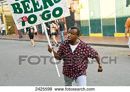 Stock Photo - Louisiana, New Orleans, Local man with beer sign in street.. Fotosearch