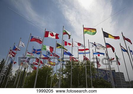 Stock Photography - Low Angle Of World Flags With Blue Sky And Clouds; Calgary Alberta Canada. Fotosearch