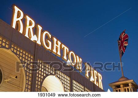 Low angle view of a Brighton pier sign lit up at dusk, East Sussex, UK., East Sussex, UK. View Large Photo Image Stock Photo - Low angle view of a Brighton pier sign lit up at dusk, East Sussex, UK., East Sussex, UK.. Fotosearch