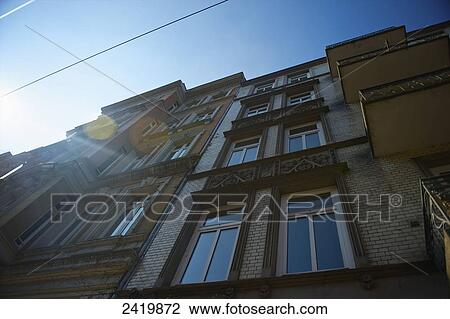 Stock Image - Low angle view of a residential brick building and blue sky; Hamburg, Germany. Fotosearch