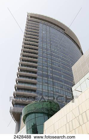 Stock Photo - Low angle view of a residential building with a curved wall and corner of balconies; Dubai, United Arab Emirates. Fotosearch