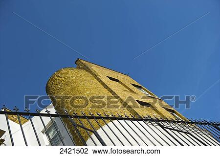 Stock Image - Low angle view of a rounded brick wall and black railing, Camden; London, England. Fotosearch