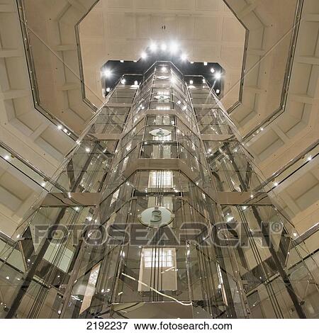 Stock Photo - Low Angle View Of An Elevator Encased In Glass; Chicago Illinois United States Of America. Fotosearch