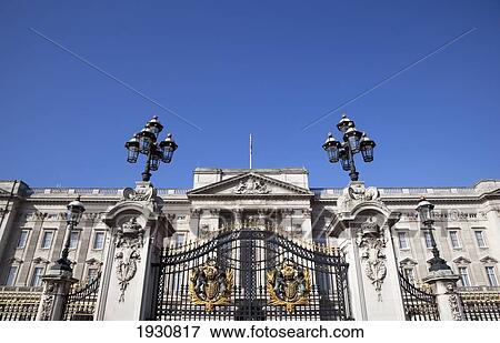 Stock Photo - Low angle view of Buckingham Palace Gates and Palace featuring the Royal Coat of Arms, London, England, London, England.. Fotosearch
