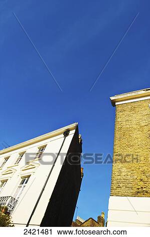 Stock Image - Low angle view of residential buildings against a blue sky, Primrose Hill; London, England. Fotosearch