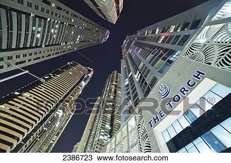 Stock Image - Low angle view of skyscrapers at nighttime; Dubai, United Arab Emirates. Fotosearch