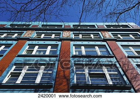 Low angle view of the facade of a building with windows against a blue sky; Hamburg, Germany View Large Photo Image Stock Image - Low angle view of the facade of a building with windows against a blue sky; Hamburg, Germany. Fotosearch